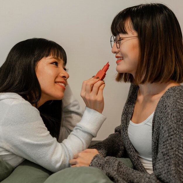 Chicas asiáticas bonitas probando productos de maquillaje