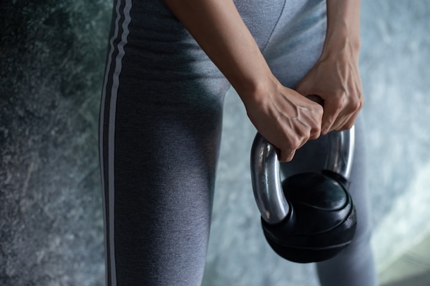 Las chicas asiáticas hacen ejercicio con el Kettlebell en el gimnasio.