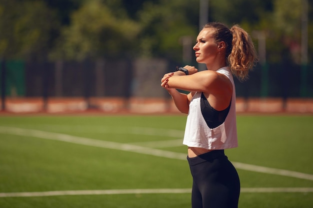 Las chicas de atletismo en el estadio hacen ejercicios.