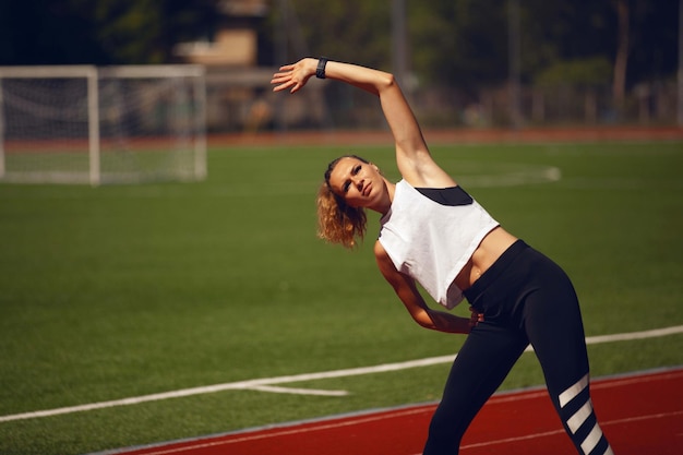 Las chicas de atletismo en el estadio hacen ejercicios.