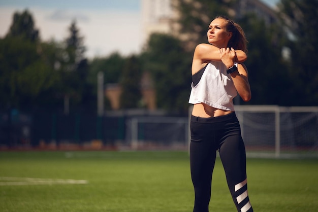 Las chicas de atletismo en el estadio hacen ejercicios.