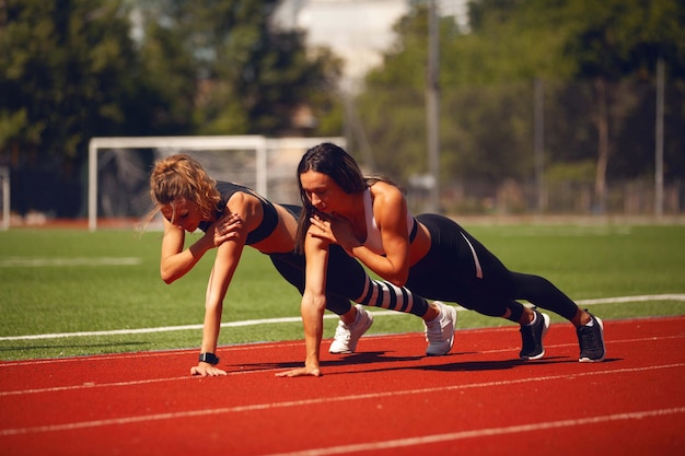 Las chicas de atletismo en el estadio hacen ejercicios.