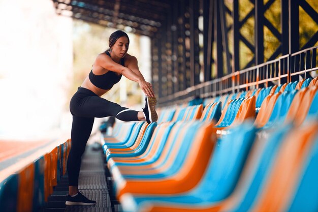 Las chicas de atletismo en el estadio hacen ejercicios.