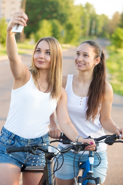 Foto gratuita chicas en bicicleta tomándose una autofoto