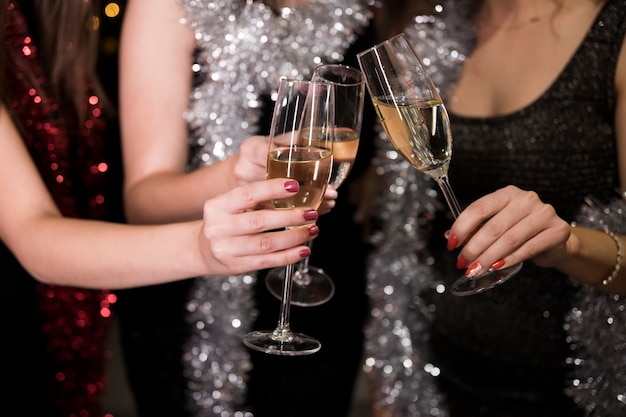 Chicas brindando con champán en fiesta de año nuevo