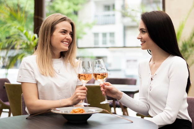 Chicas brindis con vino rosado.