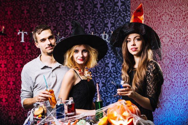 Chicas brujas y chico celebrando Halloween