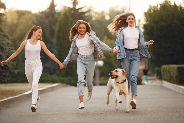 Chicas caminando en una ciudad de primavera con lindo perro