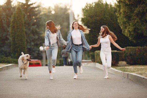 Chicas caminando en una ciudad de primavera con lindo perro
