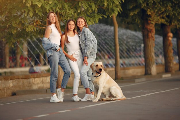 Chicas caminando en una ciudad de primavera con lindo perro