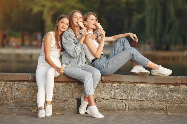 Chicas caminando en una ciudad de primavera y tienen helado en la mano