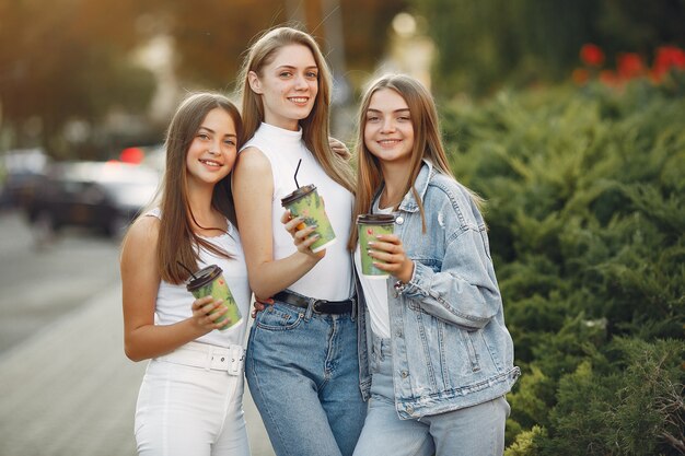 Chicas caminando en una ciudad de primavera y tomando café