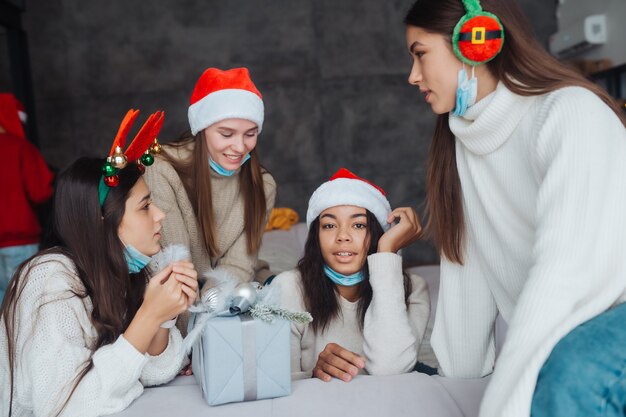 Chicas chismeando en casa en la víspera de año nuevo. Divirtiéndose en la celebración de la fiesta, bebiendo champán