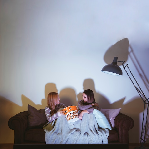 Foto gratuita chicas comiendo palomitas y haciendo una noche de película