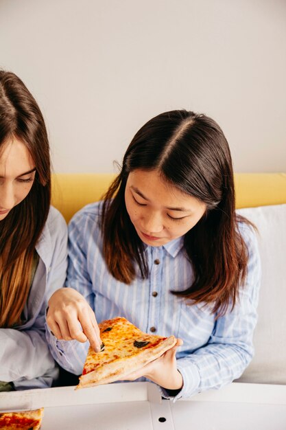 Chicas compartiendo una deliciosa pizza