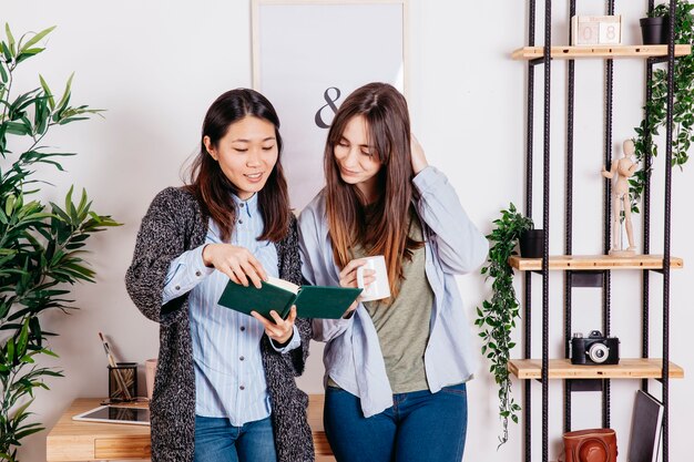 Chicas contentas leyendo un libro juntas