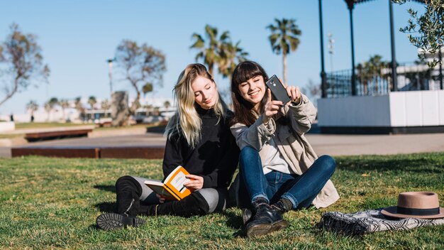 Chicas contentas tomando selfie en el parque