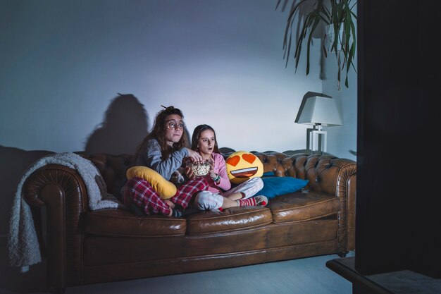 Chicas disfrutando de la película en la habitación oscura