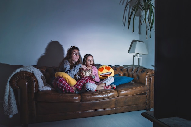 Chicas disfrutando de la película en la habitación oscura