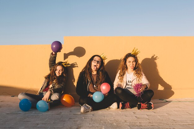 Chicas divertidas con globos en el techo