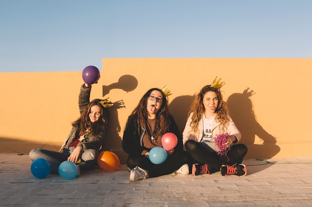 Chicas divertidas con globos en el techo