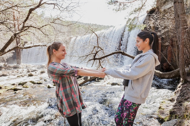 Chicas divertidas jugando junto al río