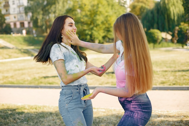 Foto gratuita chicas divirtiéndose en un parque con pinturas holi