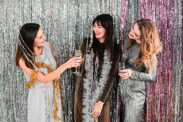 Chicas elegantes brindando con champagne