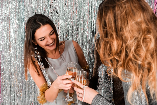 Chicas elegantes brindando con champagne