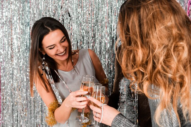 Chicas elegantes brindando con champagne