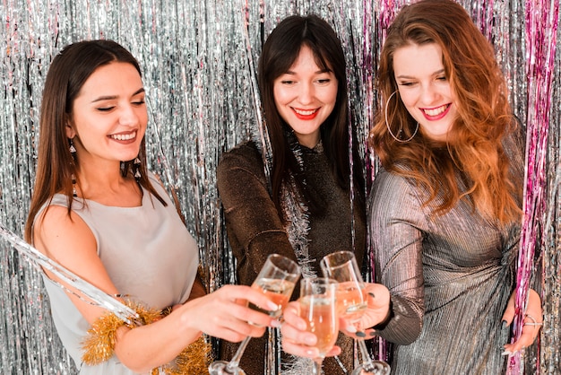 Chicas elegantes brindando con champagne