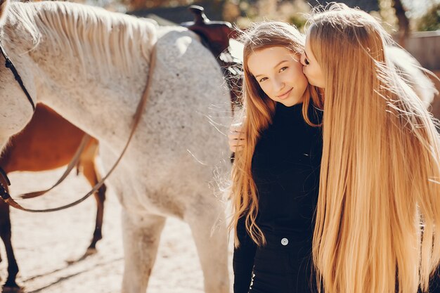 Chicas elegantes con un caballo en un rancho.