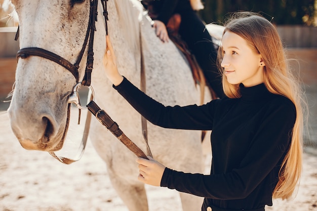 Chicas elegantes con un caballo en un rancho.