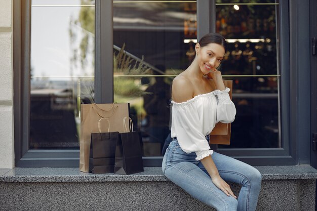 Chicas elegantes y con estilo en la calle con bolsas de compras