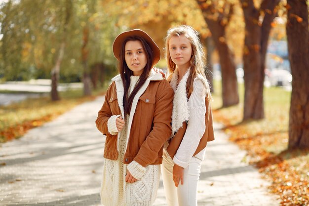 Chicas elegantes y con estilo en un parque de otoño