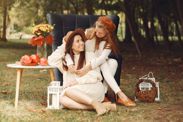 Chicas elegantes y con estilo sentado en una silla en un parque