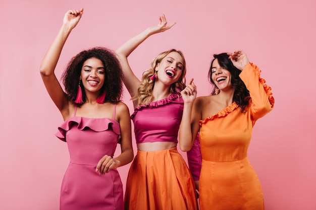 Chicas emocionadas con ropa brillante expresando felicidad Mujer latina pasando tiempo con amigos