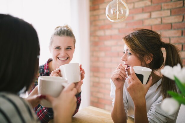 Chicas encantadoras compartiendo noticias mientras hablan