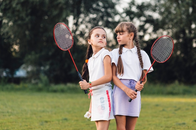 Foto gratuita chicas enojadas con bádminton en la mano mirándose