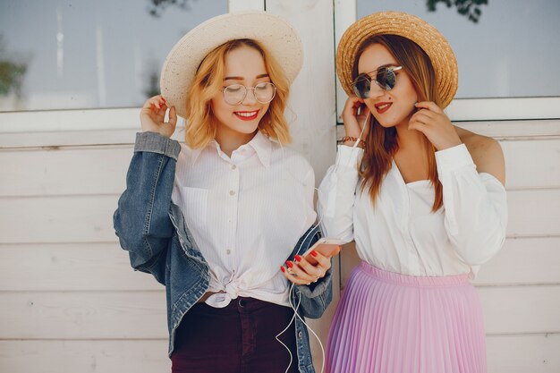 chicas con estilo de pie en una ciudad