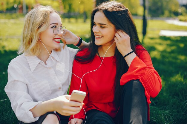 chicas con estilo sentado en un parque