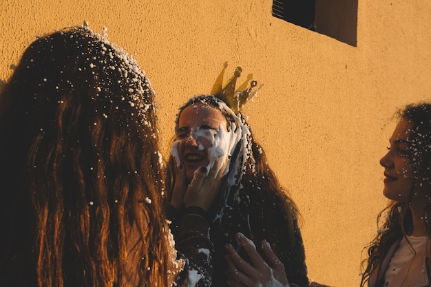 Chicas extendiendo espuma en la cara