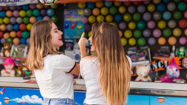 Chicas felices divirtiéndose en el parque de atracciones