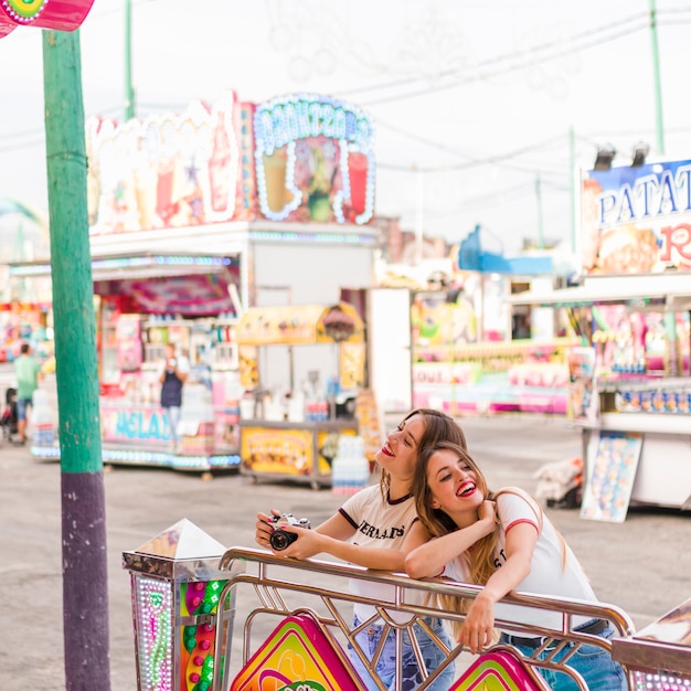 Chicas felices divirtiéndose en el parque de atracciones