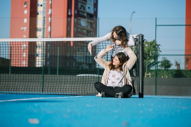 Chicas felices sentadas en azotea