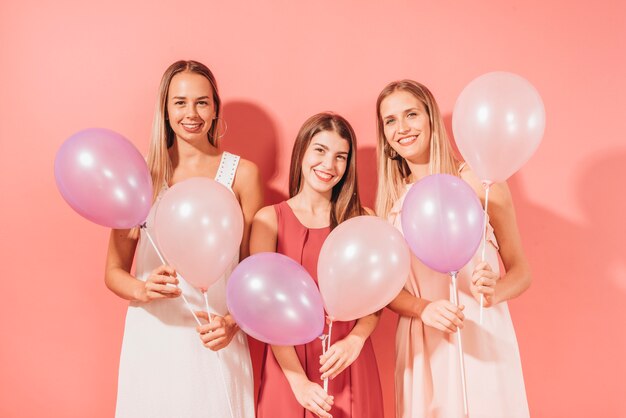 Chicas fiesteras posando con globos