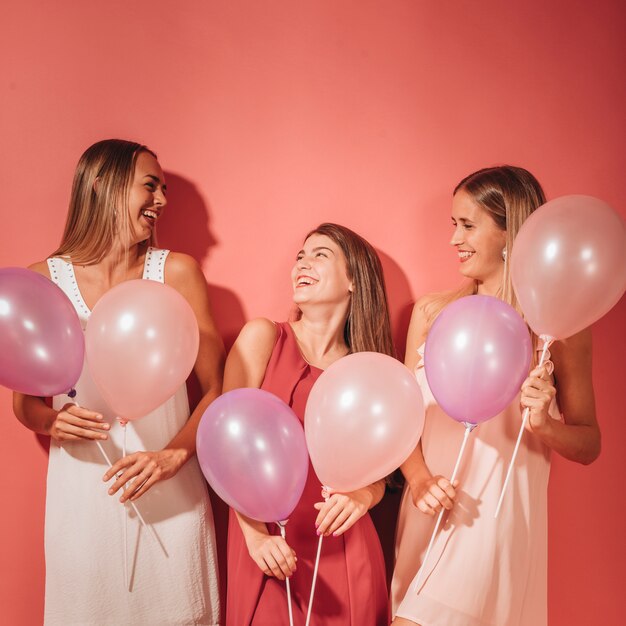 Chicas fiesteras posando con globos