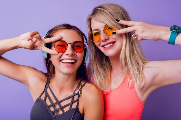 Las chicas de fitness envían un beso al aire y toman un autorretrato por teléfono móvil