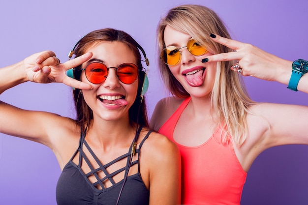 Las chicas de fitness envían un beso al aire y toman un autorretrato por teléfono móvil