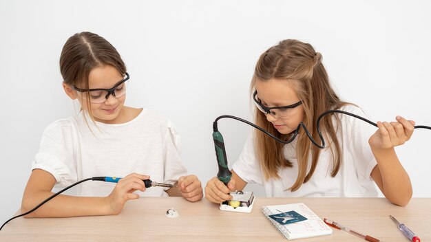 Chicas con gafas protectoras haciendo experimentos científicos juntos.